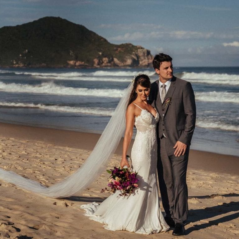 Casamento Praia do Rosa Santa Catarina casal na beira da praia com buquê após casamento