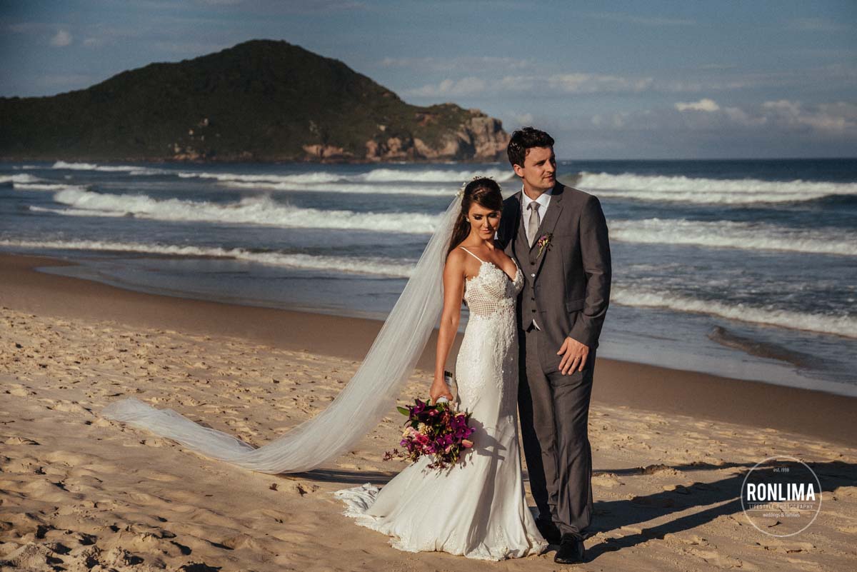 Casamento Praia do Rosa Santa Catarina casal na beira da praia com buquê após casamento