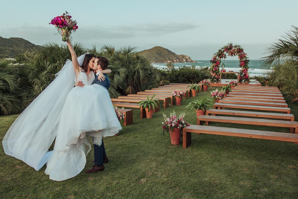 Casal de noivos celebrando casamento na praia do rosa
